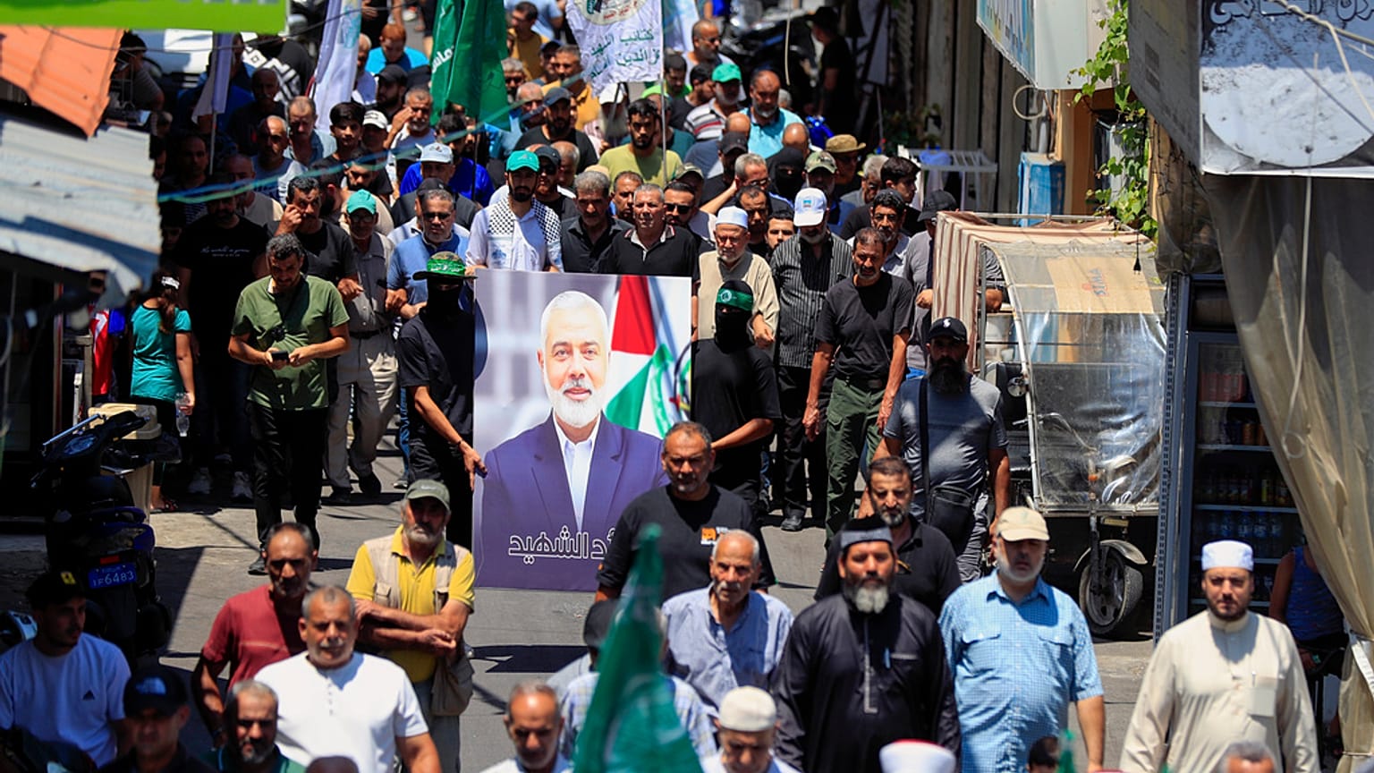 Membros do Hamas seguram um retrato do chefe político do Hamas, Ismail Haniyeh, durante um protesto para condenar a sua morte.