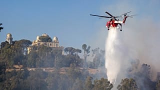 Ein Hubschrauber wirft Wasser auf das Feuer in Monte Mario in Rom.