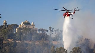 A helicopter drops water over a fire in Monte Mario, behind Piazzale Clodio in Rome, 31 July 2024