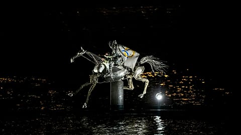 A performer on a mechanical horse carries the Olympic flag down the river Seine in Paris, France, during the opening ceremony of the 2024 Summer Olympics, July 26, 2024.