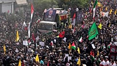 إيرانيون يتبعون الشاحنة التي تحمل نعوش القيادي في حركة حماس إسماعيل هنية وحارسه الشخصي، خلال مراسم تشييعهما في ميدان الثورة الإسلامية في طهران، إيران، الخميس، 1 أغسطس 2024