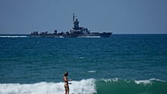Eine Surferin vor einem israelischen Kriegsschiff vor der Küste von Haifa, 1. August 2024.