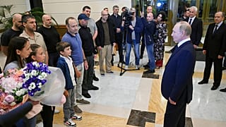 الرئيس الروسي فلاديمير بوتين، إلى اليمين، يتحدث إلى السجناء الروس المفرج عنهم لدى وصولهم إلى مطار فنوكوفو الحكومي خارج موسكو، روسيا، يوم الخميس، 1 أغسطس/آب 2024
