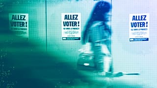A woman walks past poster reading "Go vote" ahead of the second round of the legislative election, in Strasbourg, 4 July 2024