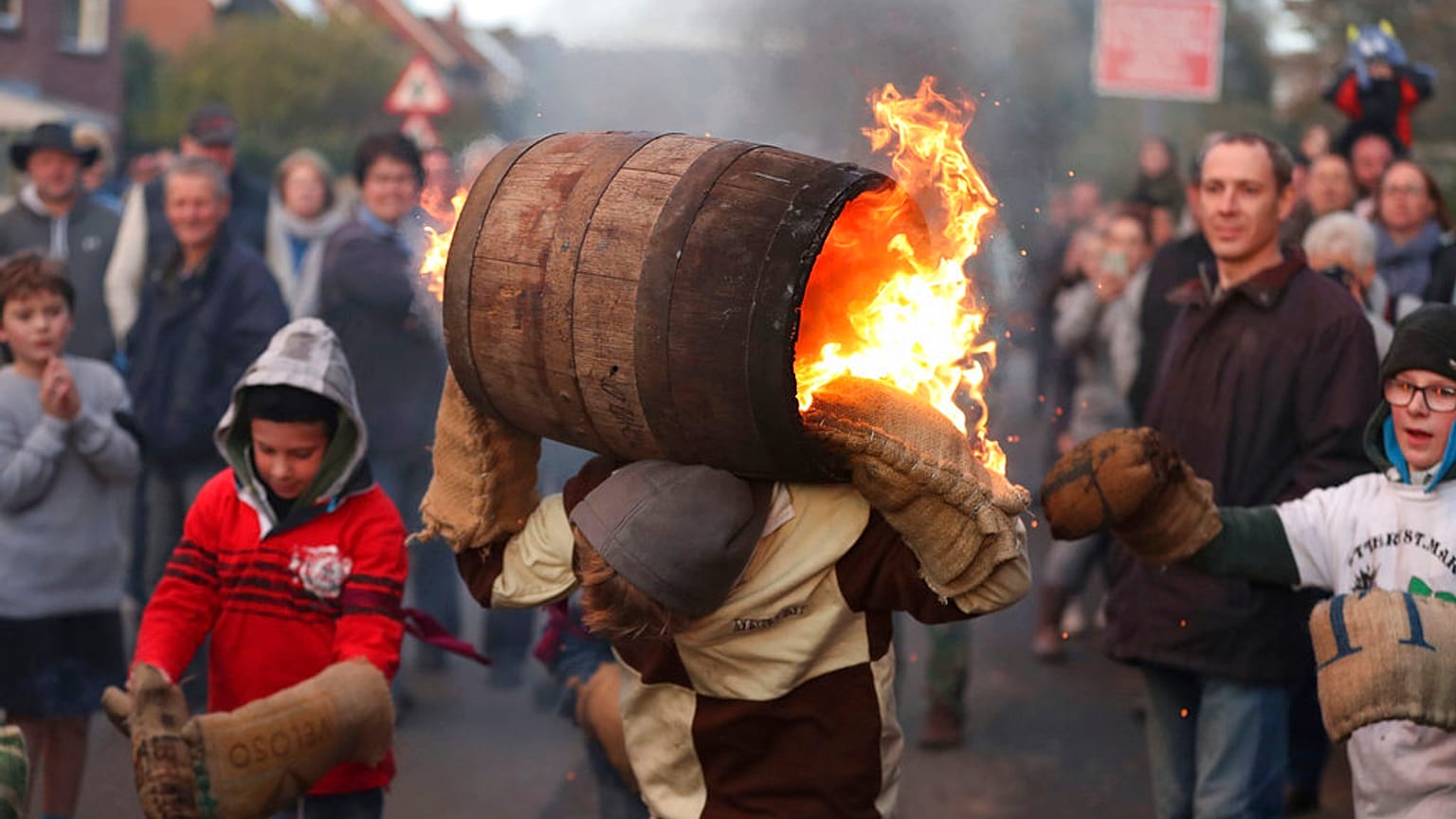 People from the Devonshire village of Ottery St Mary, southwest England, carry a traditional tar barrel through the streets of the village. 
