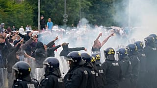 Tüntetők egy rotherhami, menekülteket elszállásoló intézményt védő rendőrsorfal előtt