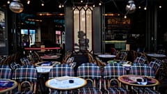 Um homem senta-se à porta de um restaurante durante os Jogos Olímpicos de verão de 2024, domingo, 28 de julho de 2024, em Paris, França.
