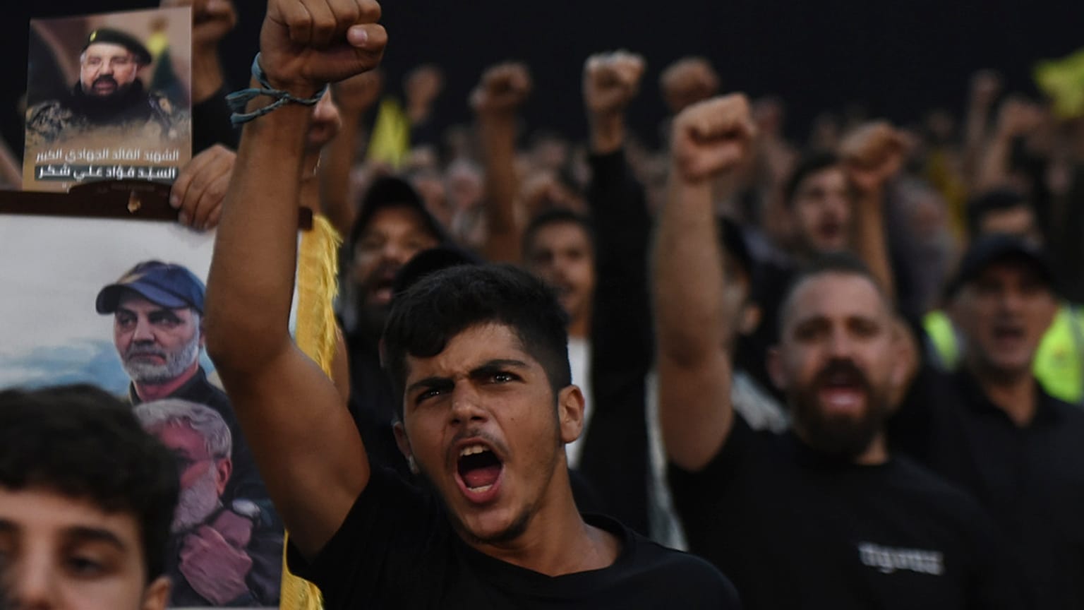 Hizbullah lideri Seyyid Hasan Nasrallah'ın 6 Ağustos 2024 Salı günü Lübnan'ın başkenti Beyrut'ta yaptığı konuşmayı ekrandan izleyen destekçileri yumruklarını kaldırarak tezahürat yapıyor.