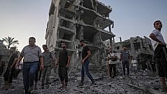فلسطينيون يقفون بين الأنقاض بعد غارة جوية إسرائيلية في دير البلح بقطاع غزة (6 أغسطس 2024)