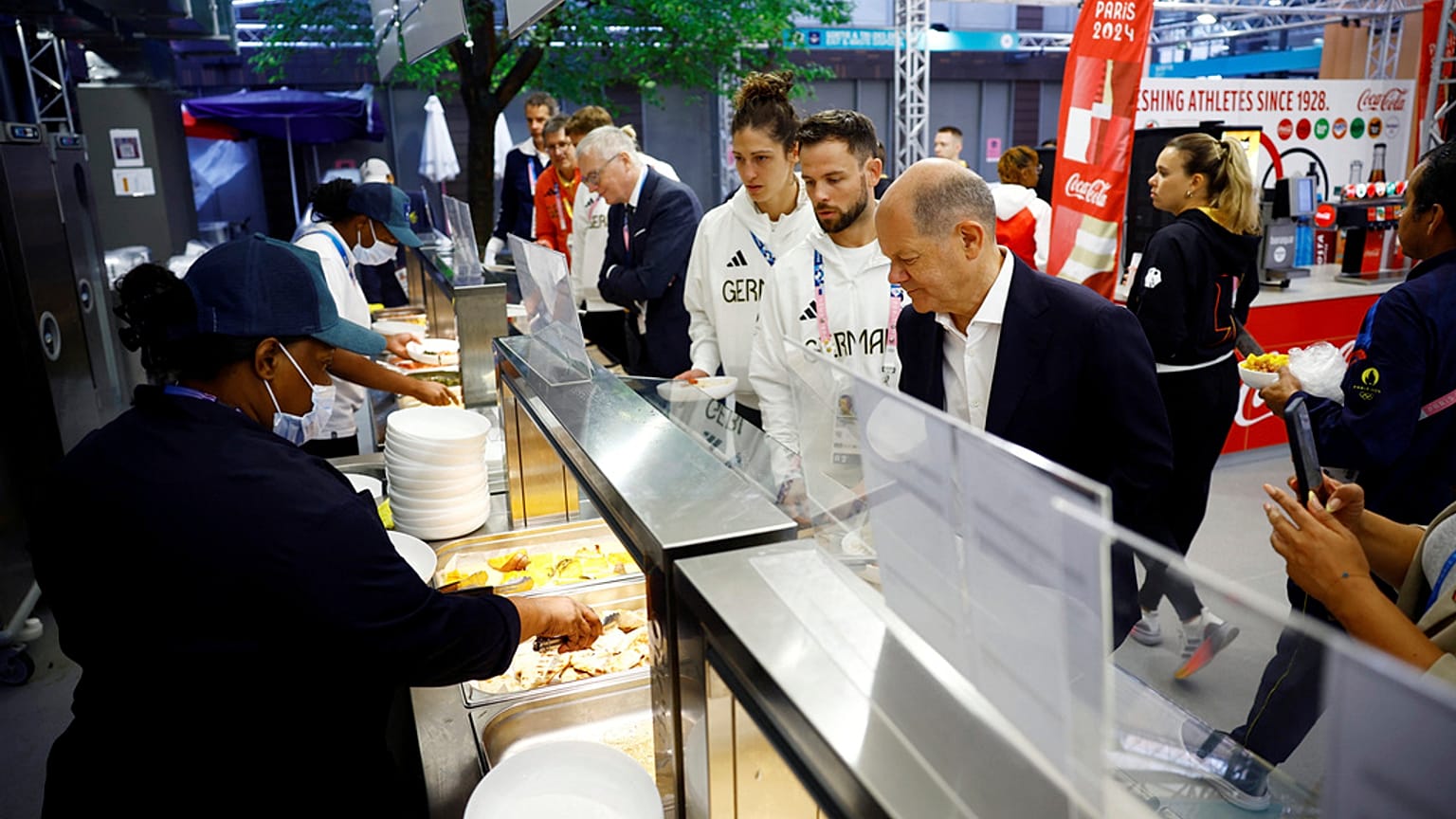 Bundeskanzler Olaf Scholz probiert das Essen in der olympischen Kantine