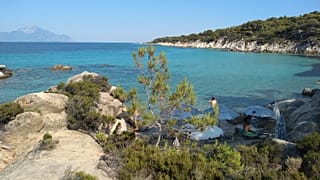 Il Monte Athos, la montagna sacra e la penisola che ospita i monasteri cristiani ortodossi, si vede di fronte al mare dalla spiaggia di Kavourotrypes il 24 luglio 2020 a Halkidiki, in Grecia.