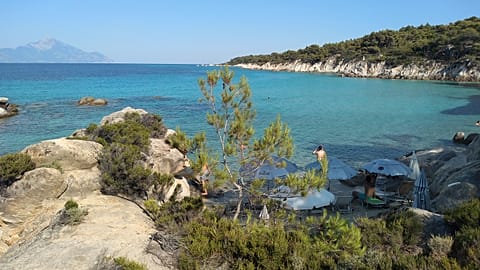 Mount Athos, the holy mountain and peninsula home to Orthodox Christian monasteries, is seen across the sea from Kavourotrypes Beach on July 24, 2020 in Halkidiki, Greece.
