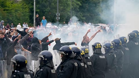 Police officers face protesters during an anti-immigration demonstration outside the Holiday Inn Express in Rotherham, England, Sunday Aug. 4, 2024