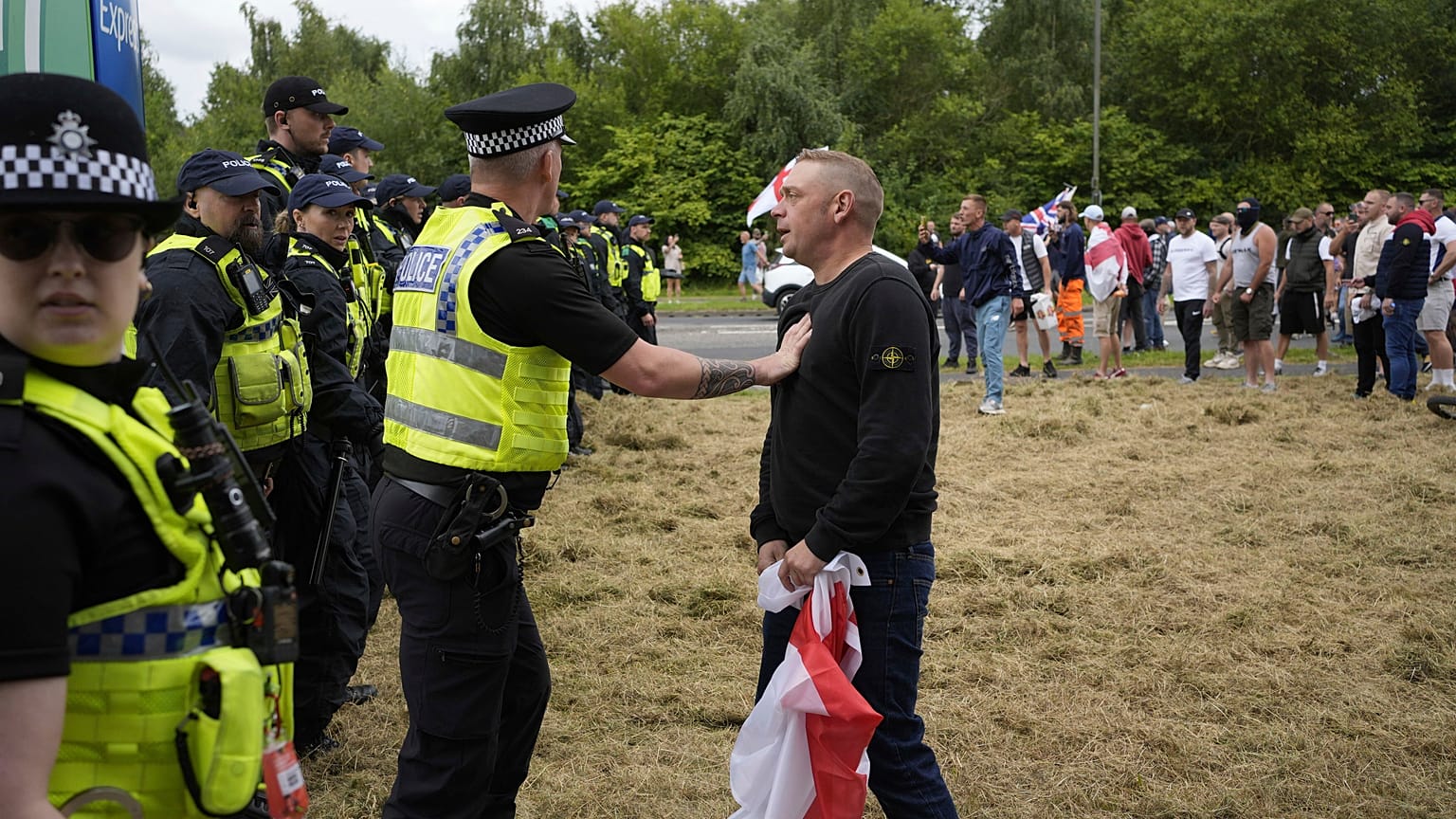 Police officers face protesters outside the Holiday Inn Express in Rotherham, England, Sunday, Aug. 4, 2024.
