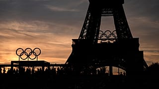 Spectators watch a quarterfinal beach volleyball match between Australia and Switzerland at sunset at Eiffel Tower Stadium at the 2024 Summer Olympics, Tuesday, Aug. 6, 2024