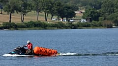 Ein Jetski zieht Bojen von den CrossFit Games am Marine Creek Lake ein, wo ein Athlet während des Schwimmwettbewerbs am Donnerstag, 8. August 2024 in Fort Worth, Texas, ertrunken ist.