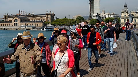 In this Wednesday, May 25, 2016 photo, tourists walk at the Maremagnum Port in Barcelona, Spain