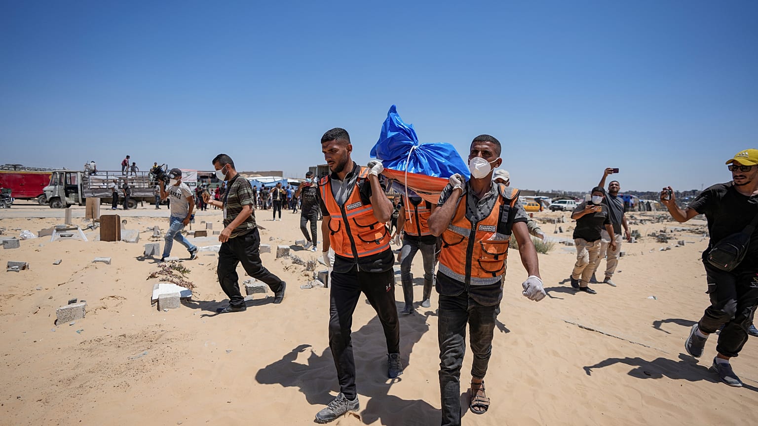 عمال يحملون جثمانًا أعادته إسرائيل إلى مقبرة في خان يونس بقطاع غزة، الاثنين، 5 أغسطس/آب 2024.