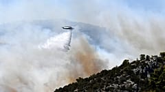 Un hélicoptère largue de l'eau sur un incendie à Nea Makri, à l'est d'Athènes, le lundi 12 août 2024.