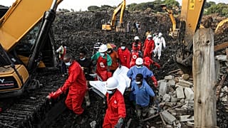 Kızıl Haç personeli, 11 Ağustos 2024 Pazar günü Uganda'nın Kampala kentinde çöken bir çöp sahasında bir kurbanın cesedini taşıyor.