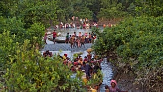 Rohingyák kelnek át a Naf folyón Mianmarból Bangladesbe 2017-ben, a rohingyák elleni népirtások idején