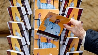 People buy postcards depicting Pope Francis in Rome, Friday, March 15, 2013.