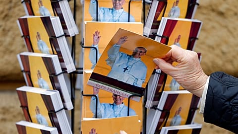 People buy postcards depicting Pope Francis in Rome, Friday, March 15, 2013.