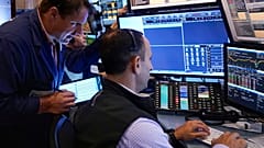 Trader Michael Milano. left, works with colleagues on the floor of the New York Stock Exchange, Wednesday, Aug. 7, 2024. 