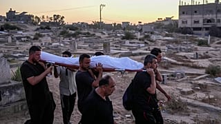 Un grupo de palestinos traslada hacia el cementerio el cuerpo de una víctima de los ataques israelíes, en Deir al-Balah (Gaza), el pasado viernes.