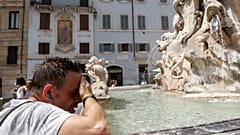 Un homme se rafraîchit à la fontaine de Trevi dans le centre de Rome, le mercredi 11 août 2021.