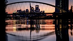 The European Central Bank and the banking district are reflected in the river Main after sunset in Frankfurt