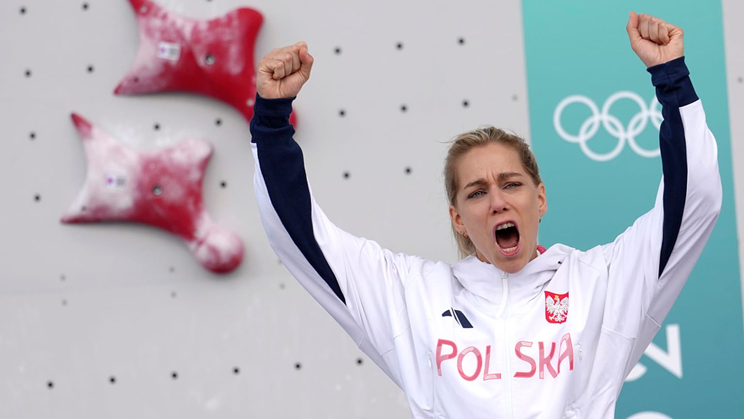 Gold medallist Aleksandra Miroslaw of Poland celebrates on the podium after winning the women's speed climbing final at the 2024 Olympics, Aug. 7, 2024, in Le Bourget, France