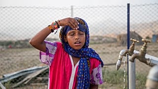 7-year-old Madina Mohamed Awad faces her face with clean water at a new water station in the small village of Gelhanty in Sudan