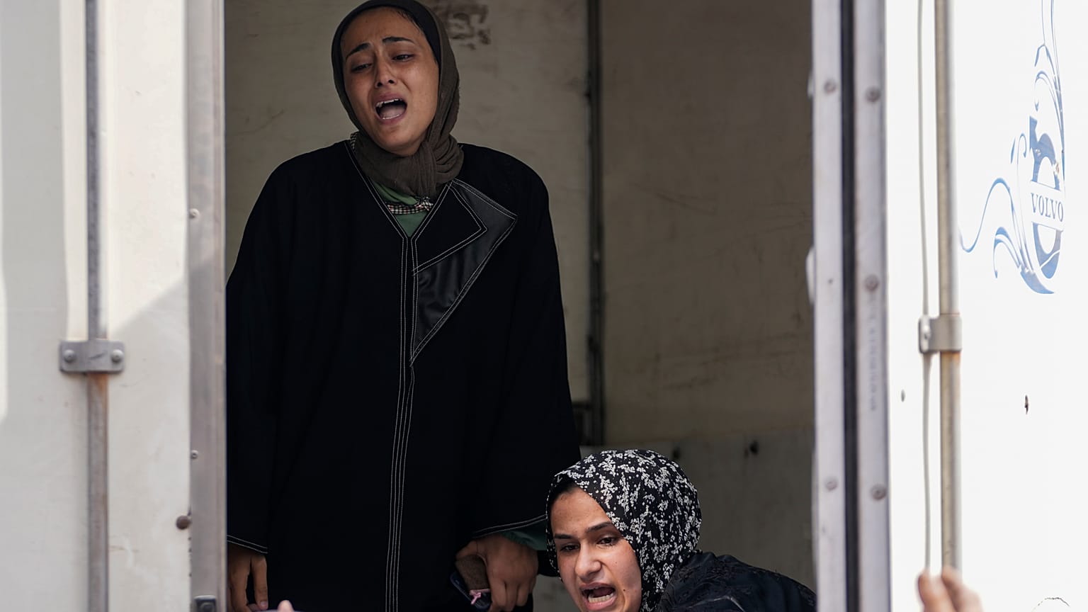 فلسطينيات يحيين جنازة أكثر من 18 شخصاً، من بينهم عدد من الأطفال والنساء، الذين قُتلوا في غارة إسرائيلية وذلك في مستشفى الشهداء الأقصى في دير البلح، قطاع غزة، يوم السبت 