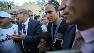 الجزائرية إيمان خليف، تحمل الزهور أثناء وصولها بعد عودتها من دورة الألعاب الأولمبية 2024 في تيارت، الجزائر، الجمعة 16 أغسطس 2024