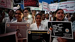 Des médecins et des étudiants en médecine tiennent des pancartes et des bougies lors d'une manifestation contre le viol et le meurtre d'un médecin stagiaire à Kolkata la semaine dernière, 17 août 2024.
