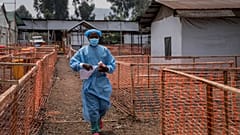 Bir sağlık çalışanı, Doğu Kongo'nun Munigi kentinde bir mpox tedavi merkezinin önünden geçiyor, 16 Ağustos 2024.