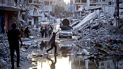 ملف - فلسطينيون نزحوا بسبب الهجوم الجوي والبري الإسرائيلي على قطاع غزة، يسيرون بجوار مياه الصرف الصحي المتدفقة إلى شوارع مدينة خان يونس الجنوبية، قطاع غزة، الخميس 4 يوليو 2024