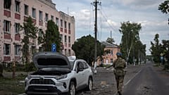 Un soldato ucraino passa davanti al municipio di Sudzha, nella regione di Kursk, in Russia (16 agosto 2024)