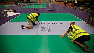 Des ouvriers préparent le terrain de boccia lors d'une visite de l'Arena Paris Sud en vue des Jeux Paralympiques, lundi 19 août 2024 à Paris. 