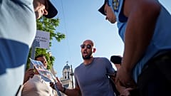 Social media influencer Andrew Tate talks to gendarmes during a protest near the French Embassy in Bucharest, Romania, Sunday, July 28, 2024