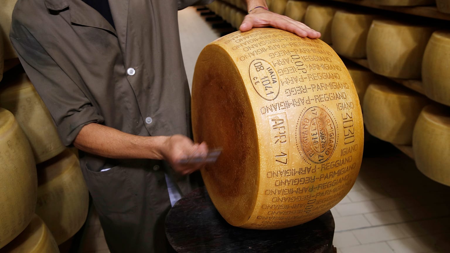 Quality control employee inspects a Parmigiano Reggiano Parmesan cheese in Noceto, Parma, Italy, Tuesday, Oct. 8, 2019.