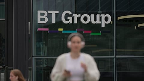 A woman walks in front of the BT headquarters, in London, Thursday, May 18, 2023. 