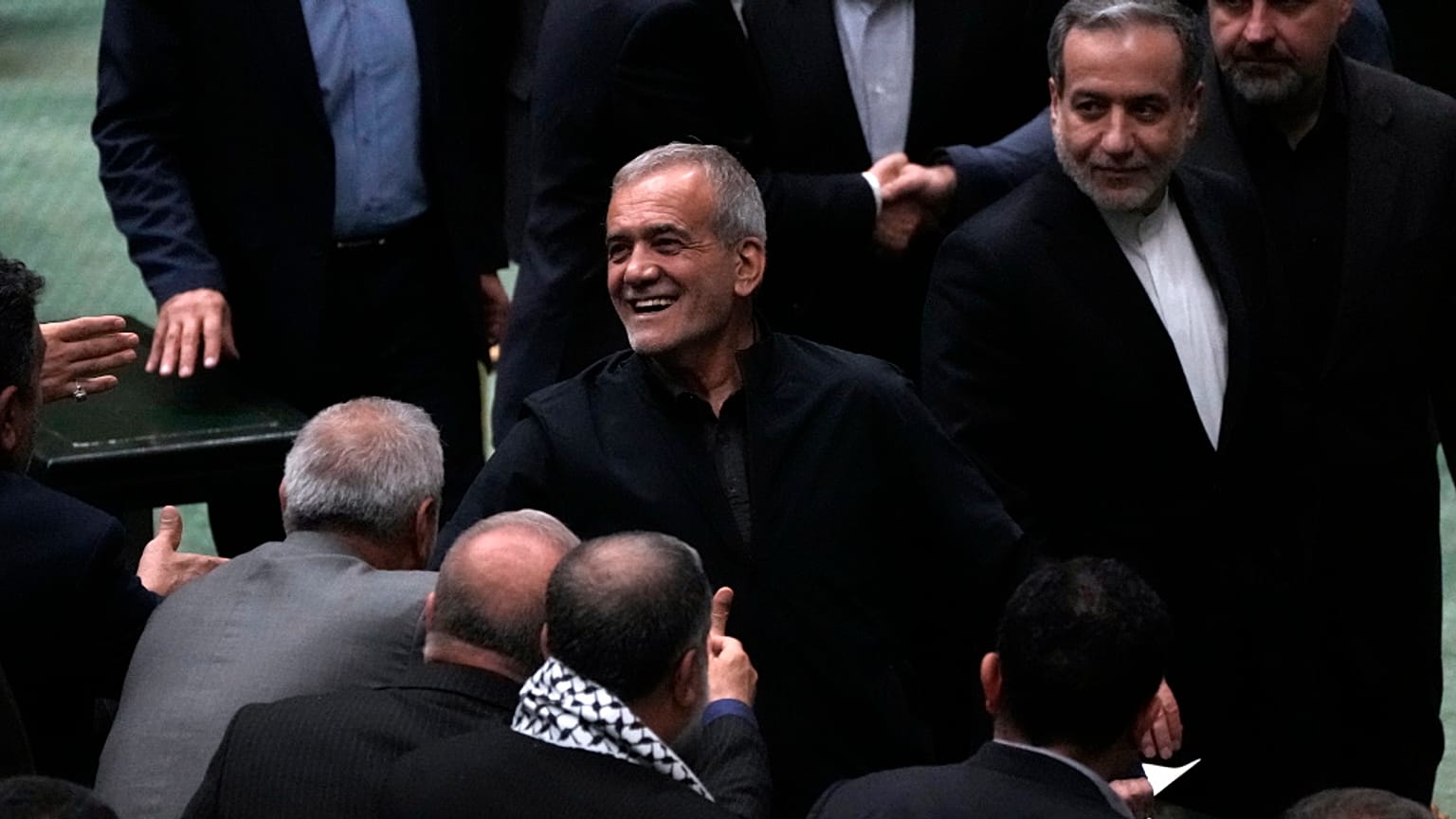 الرئيس الإيراني مسعود بيزشكيان، في الوسط، يستقبله المشرعون أثناء مغادرة البرلمان بعد اختتام خطابه خلال المناقشة حول وزرائه المقترحين، في طهران، إيران، الأربعاء، 21 أغسطس، 2024
