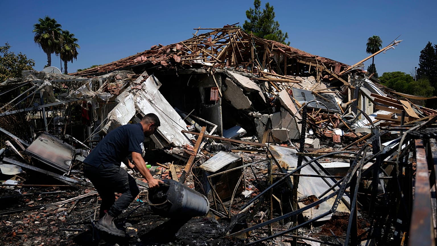 Un uomo vicino a una casa distrutta dopo il lancio di razzi a Katzrin, nelle Alture del Golan annesse a Israele, 21 agosto 2024