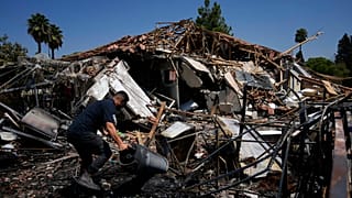 Un uomo vicino a una casa distrutta dopo il lancio di razzi a Katzrin, nelle Alture del Golan annesse a Israele, 21 agosto 2024