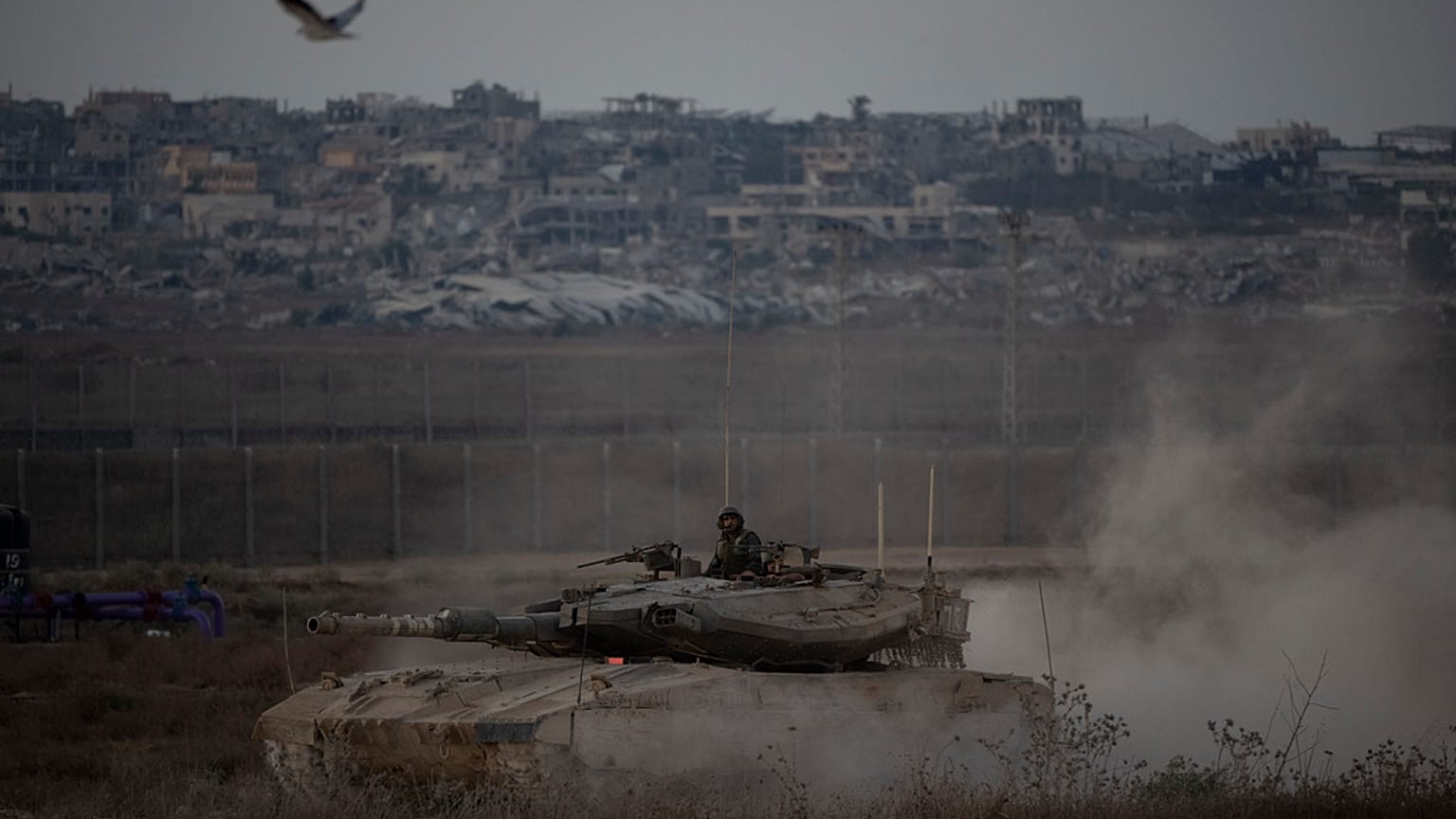 Des soldats israéliens se déplacent sur le toit d'un char près de la frontière entre Israël et Gaza, vu du sud d'Israël, le mercredi 21 août 2024.
