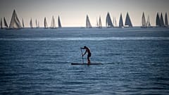 A man paddles in the Mediterranean Sea in Barcelona, Spain.