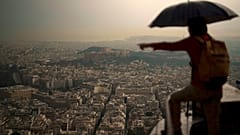 Τουρίστας με ομπρέλα στο Λυκαβηττό κατά τη διάρκεια βροχής στην Αθήνα