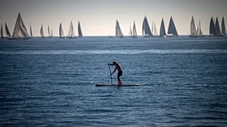 A man paddles in the Mediterranean Sea in Barcelona, Spain.